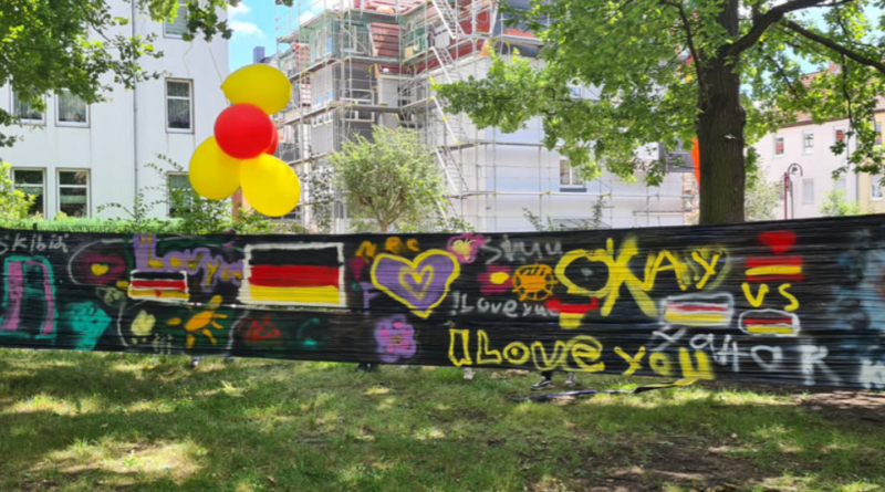 ooperationsprojekt "Erlebnis-Projekt – Europa ohne Mauern" Viele bunte Graffiti auf einer schwarzen Plane.